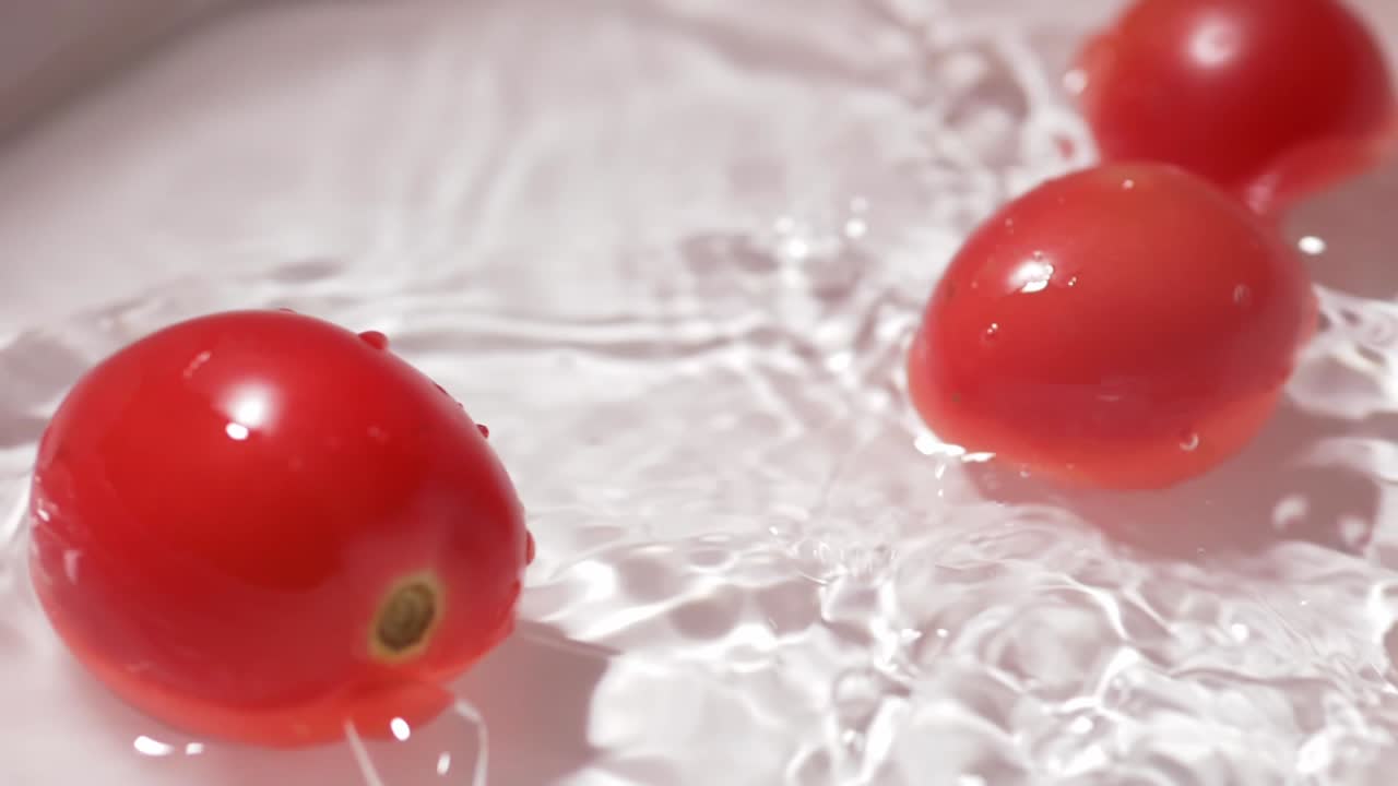 슬로우 모션 신선한 토마토는 낙관적이고 건강해 보이는 신선한 물 청소 개념으로 떨어집니다.