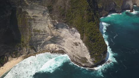 Aerial-view-of-the-tourist-hotspot-Kelingking-beach-on-Nusa-Penida,-Indonesia-on-a-sunny-day-and-with-crystal-blue-water