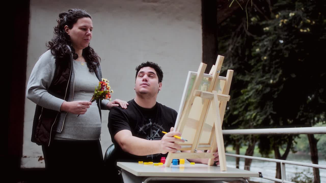 Man Painting on Easel While Woman Observes