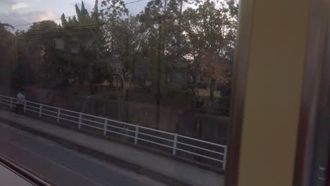 local-countryside-landscape-view-through-train-window-while-train-moving-fast-in-japan-daytime,-natural-view-on-the-side-of-railway-track