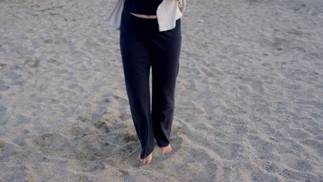 Unrecognisable-female-dancer's-legs-and-feet-at-sandy-beach,-moving-by-the-sea