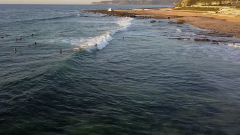 mereweather beach surfer monta olas en la costa al amanecer, australia