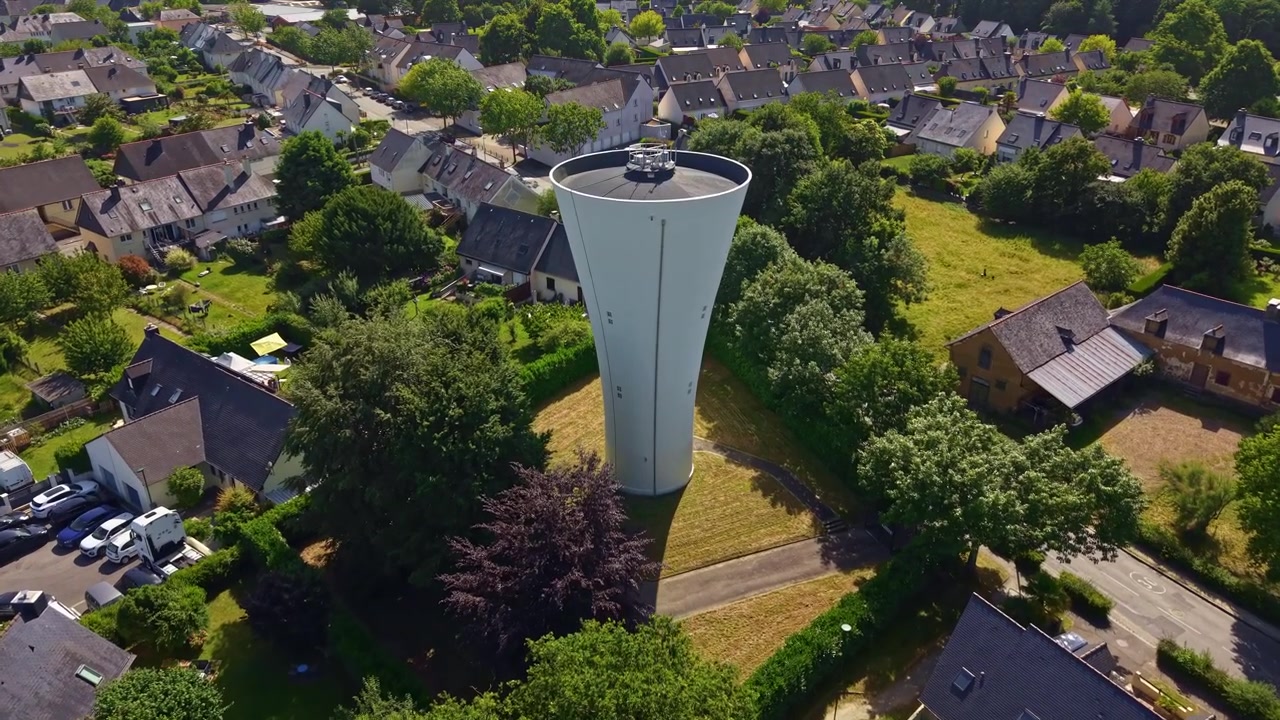 Ein moderner Wasserturm steht über einem Wohnviertel in Chavagne