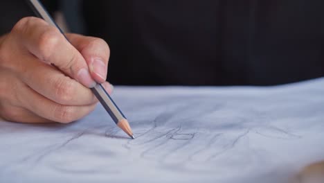 close up of person sketching a drawing with a wooden pencil