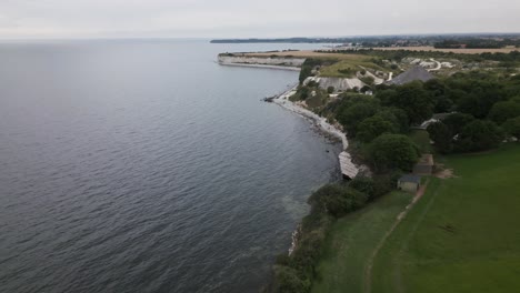 drone flight along some cliffs at the sea in denmark with birds