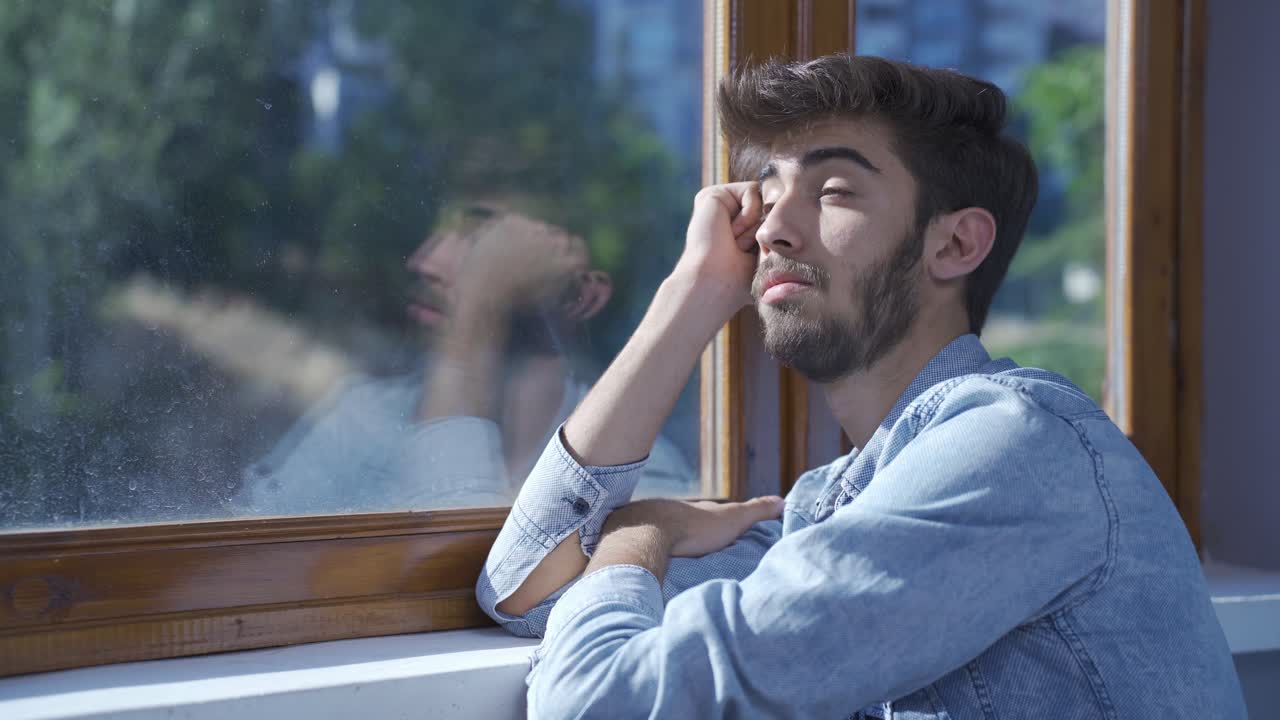 考え深い男が外を見ている.