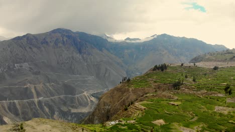 Aerial-shot-of-Colca-Canyon-over-green-fields