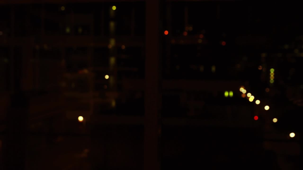 Data analyst tapping tablet in night office, aligning 3D charts with device and analyzing metrics