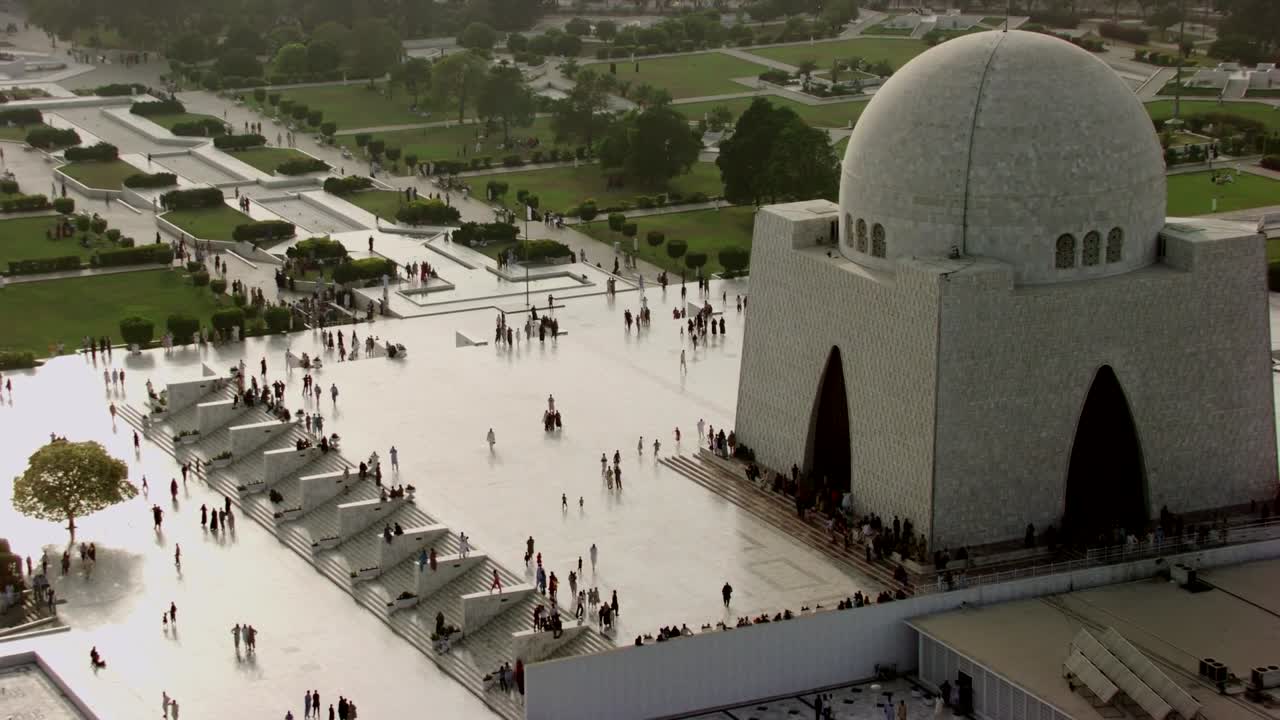A stunning aerial shot of the Mausoleum of Muhammad Jinnah, also known as Mazar-e-Quaid, located in Karachi, Pakistan. The white marble structure with its grand dome and arched entrances