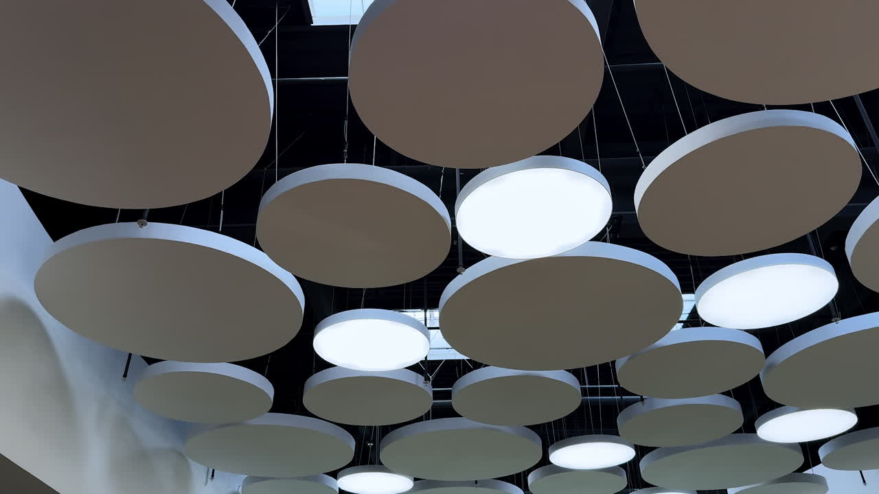Unusual design elements on the ceiling of the room. Low angle view. Light and decor in the interior