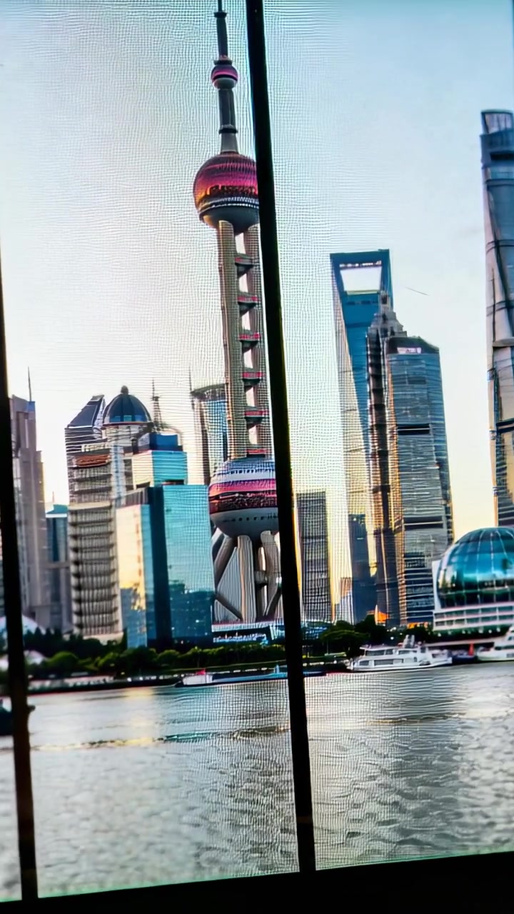 Vídeo vertical: Câmera do celular em panorama centralizando a Torre Pérola em uma janela interna, mostrando barcos