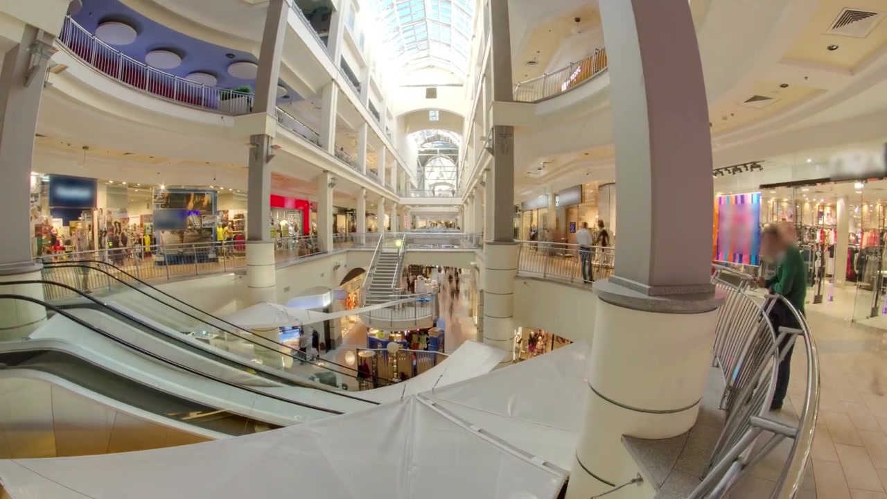 Mange butikker i et stormagasin eller indkøbscenter i flere etager timelapse hyperlapse. Rulletrappe mellem etagerne