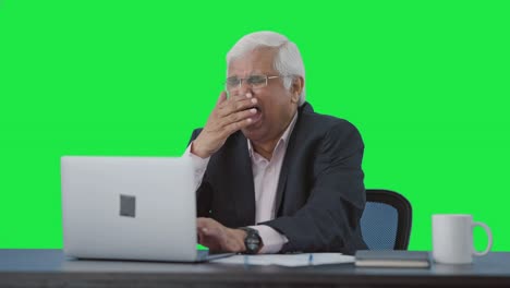 Sleepy-and-lazy-senior-Indian-manager-working-on-laptop-Green-screen