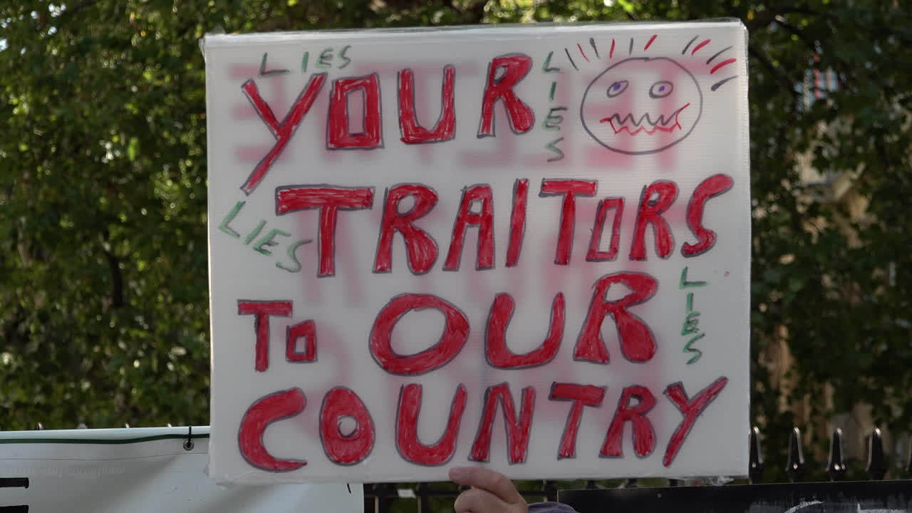 на акции протеста против введения ограничений безопасности по "правилу шести", посвященной коронавирусному заговору, был поднят плакат с надписью "предатели нашей страны".