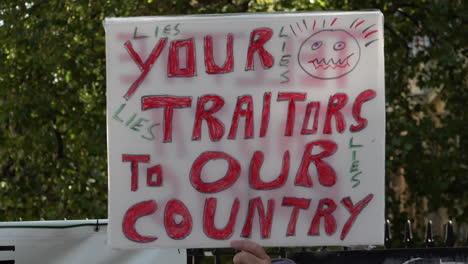 a misspelt handmade placard is held up that says, “your traitors to our country” on a coronavirus conspiracy protest opposing the introduction of the “rule of six” safety restrictions