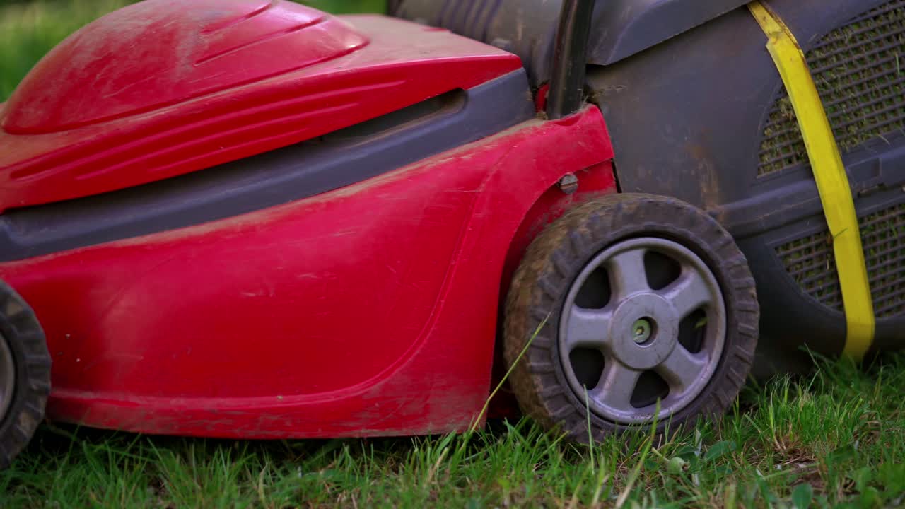Lawn mower on green grass. Close up of grassmower mowing the grass