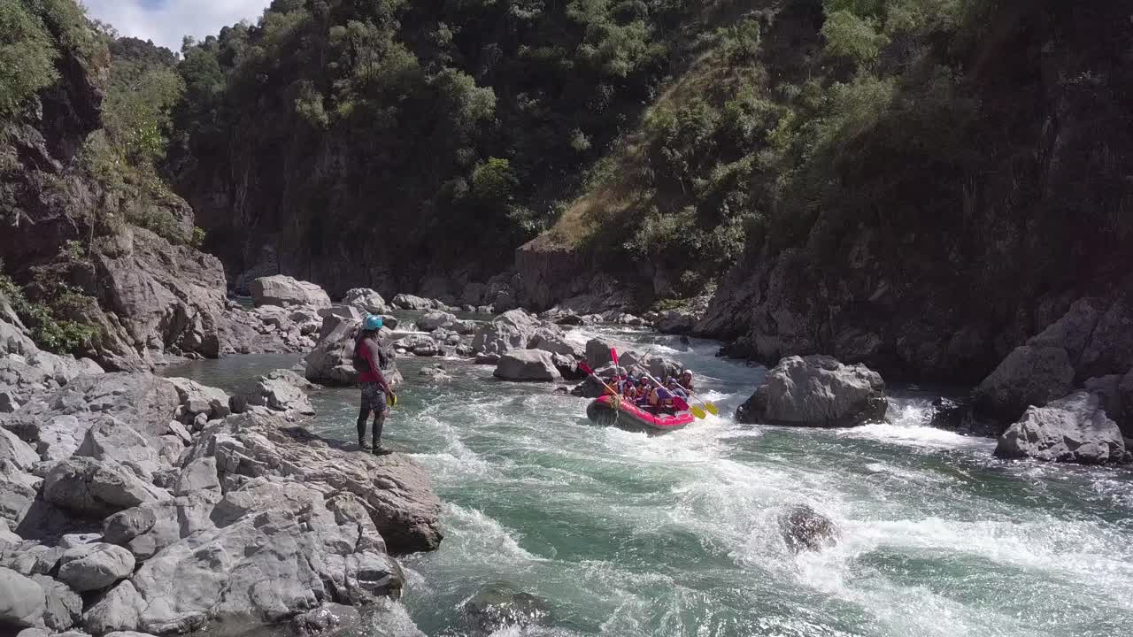 New Zealand, a lifeguard looking after the people on the raft while going down stream - wide shot