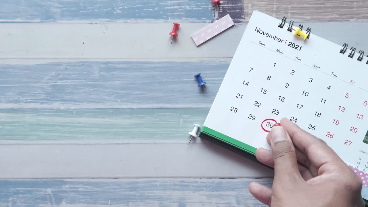 mano señalando el 30 de noviembre de 2021 en un calendario