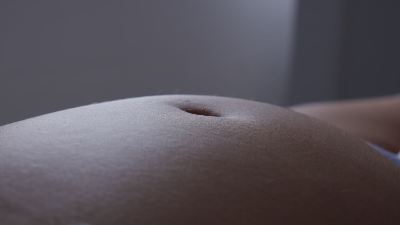 Close-up of a pregnant belly with baby kicking from within