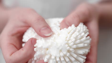 woman apply shampoo and white bath sponge before shower, close up