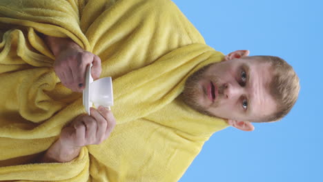 man in a yellow robe drinking coffee