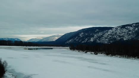 Beautiful-Aerial-Footage-of-Frozen-North-Thompson-River-and-Snow-Covered-Mountains-in-BC,-Canada