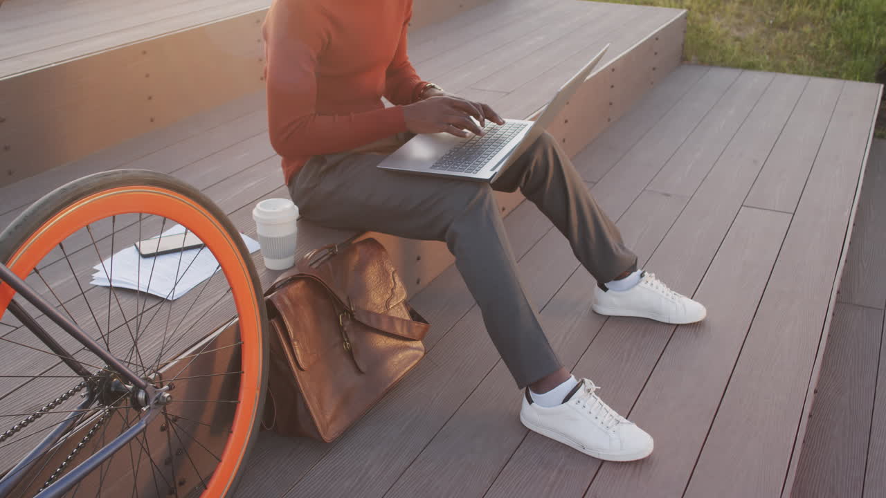 Man with Bike Working on Laptop Outdoors