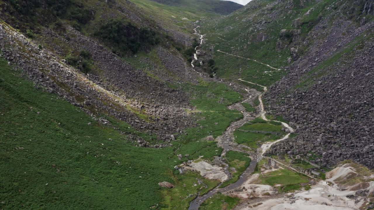 fotografía aérea de un arroyo que desemboca en el lago superior de glendalough en el parque nacional de las montañas wicklow en irlanda