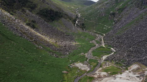 aerial shot of stream flowing into glendalough upper lake in wicklow mountains national park in ireland