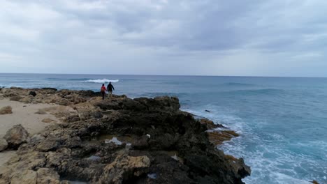 pareja caminando por la costa rocosa 4k