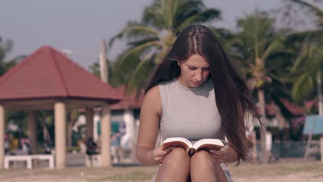 pretty-lady-with-long-hair-waved-by-wind-sits-and-reads