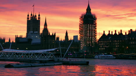 houses of parliament with scaffolding at sunset