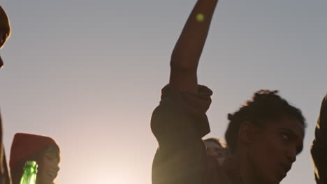 des amis heureux dansant célébrant sur le toit au coucher du soleil profitant de la fête week-end s'amusant socialisant traînant boire de l'alcool