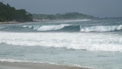 waves crashing along overcast indonesian coast