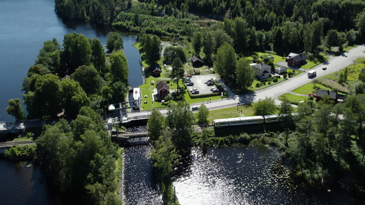 Långbrons Slusstation, Dals Långed, aerial shot of a serene countryside landscape with a train passing by