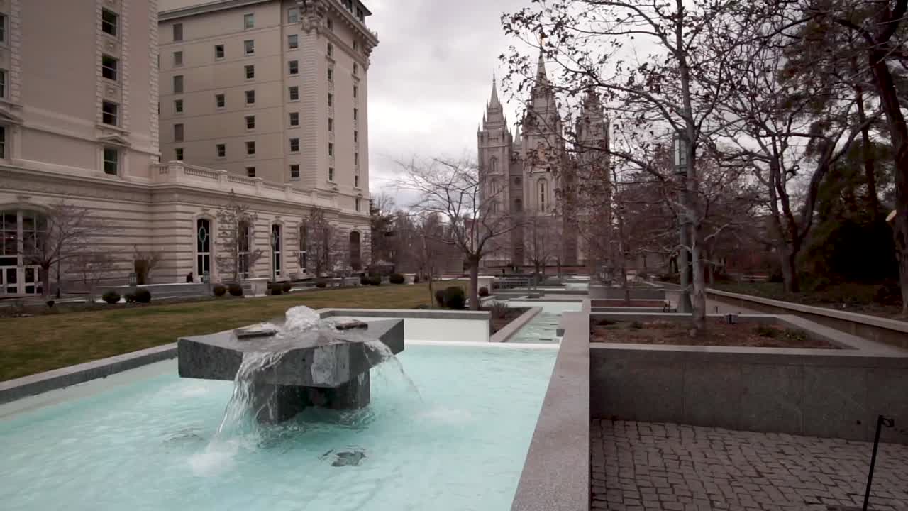 Static shot of the Salt Lake City Mormon Temple with a water fountain in the foreground