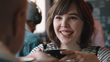 Feliz-Adolescente-Charlando-Con-Un-Amigo-En-La-Cafetería-Bebiendo-Café-Riendo-Disfrutando-De-Una-Conversación-De-Chismes-Pasando-El-Rato-En-Un-Concurrido-Restaurante-Para-Almorzar.