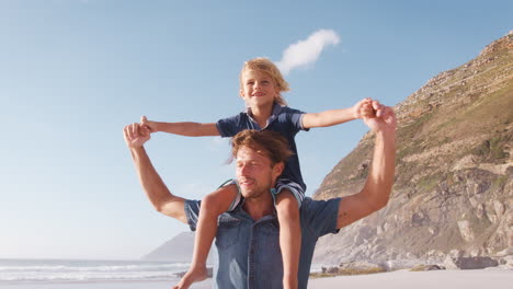 father and son on summer vacation playing on beach together