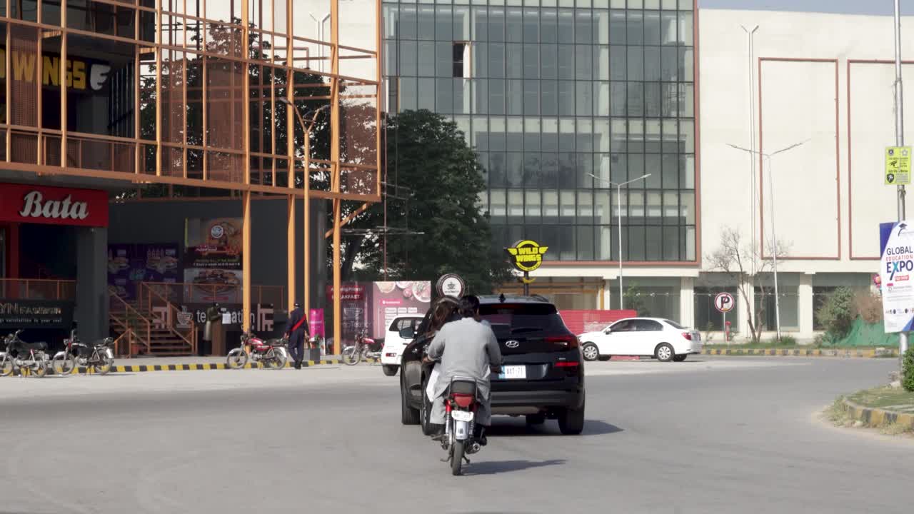 This is a stunning capture of a bustling street lined with towering commercial structures in all their splendor as cars zoom past.