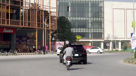 this is a stunning capture of a bustling street lined with towering commercial structures in all their splendor as cars zoom past.