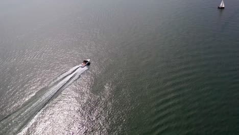 aerial drone footage following motorboats on lake biel and showing off the blue waters and gorgeous scenery