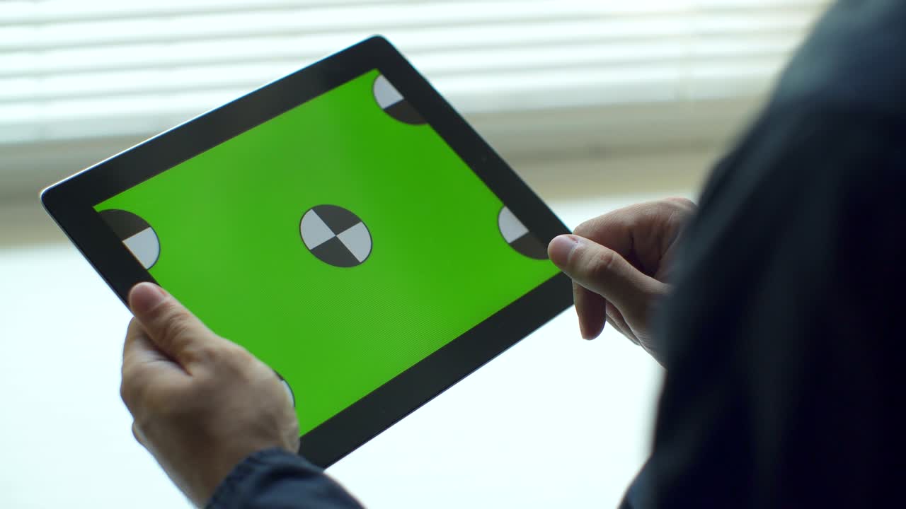 태블릿을 사용하는 사람.녹색 화면을 가진 태블릿