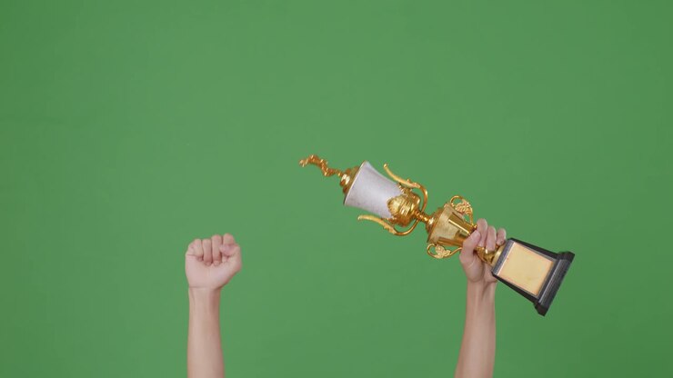 Raised Hands Of A Man Are Holding A Trophy. Green Screen Background