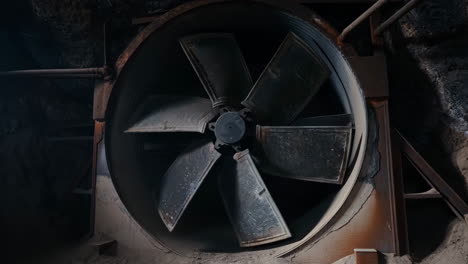 rusty industrial fan in a dark underground space