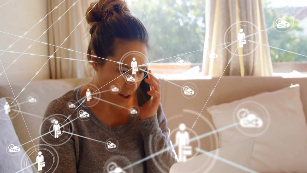 Femme assise sur un canapé dans une pièce ensoleillée, utilisant un smartphone et un ordinateur portable affichant une superposition de réseau technologique.