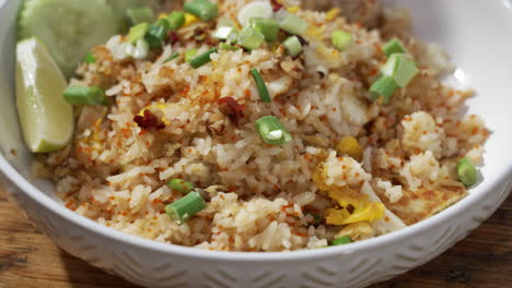 Plated-dish-of-restaurant-crab-fried-rice-topped-with-green-onions,-close-up-slider-4K