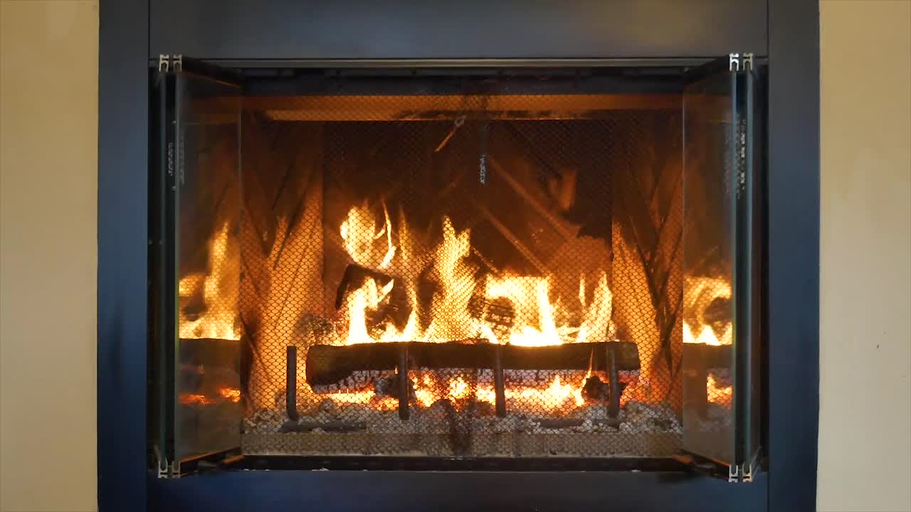 집안에서 뜨겁고 밝은 나무를 태우는 벽난로의 직선 샷