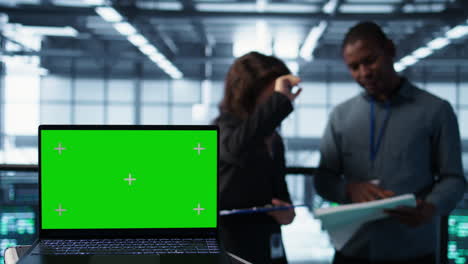 chroma key notebook used by coworkers adjusting server room configurations