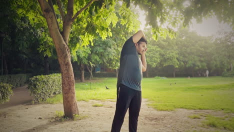 indian man doing side bending exercise at outdoor during morning sunrise