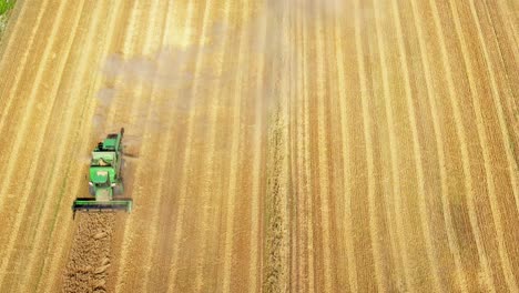 top down view of harvester machines working in wheat field